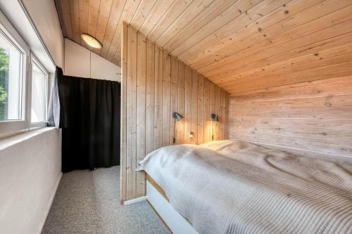 a bedroom with a bed in a wooden wall at C11734-Hemmet-Kirkehojvej-40-L6 in Hemmet