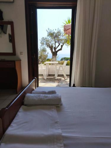 a bedroom with two beds and a view of a table at Villa Frideriki in Agia Paraskevi