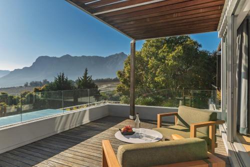 a patio with a table and chairs on a balcony at Clouds Estate in Stellenbosch