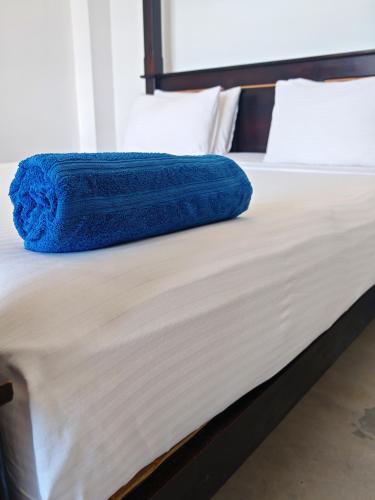 a blue blanket laying on top of a bed at Waves Hiri Sea View in Hiriketiya