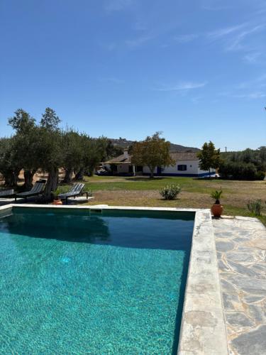 a swimming pool with blue water in a yard at Monte de Santa Maria in Monsaraz