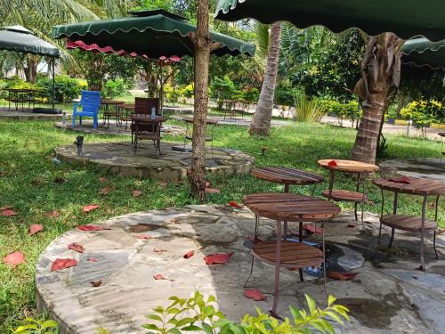 a group of tables and chairs under an umbrella at Escape Hole in Diani Beach