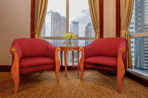 two chairs and a table in front of a window at Richmonde Hotel Ortigas, Manila in Manila
