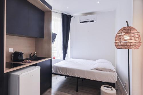 a small bedroom with a bed and a window at LES BULLES DE MONA - Alcove - Spa - Clim in Lyon