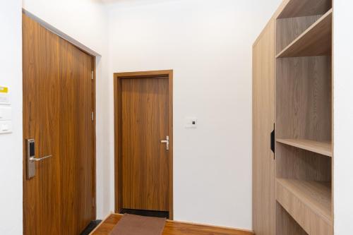 a hallway with two wooden doors and wooden shelves at Villa Sea in Trà Cổ