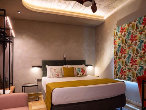 a bedroom with a large bed with a yellow blanket at The Mdina Heritage Boutique Hotel - By Luxury Villas International in Rabat