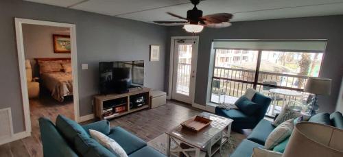ein Wohnzimmer mit einer blauen Couch und einem Fernseher in der Unterkunft Saida Beachfront Luxe Condo two heated pools condo in South Padre Island