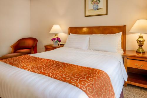 a hotel room with a large bed and a chair at Richmonde Hotel Ortigas, Manila in Manila
