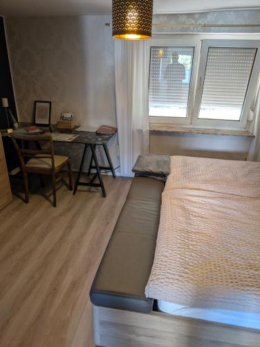 a bedroom with a bed and a desk and a table at FeWo Altstadt BL in Bad Laasphe