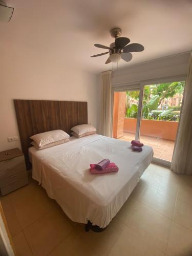 une chambre avec un lit avec deux pantoufles dessus dans l'établissement Superb 2 Bed Apartment on Mar Menor Golf Resort with Free WIFI, à Los Martínez