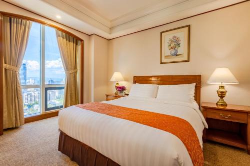 a hotel room with a bed and a large window at Richmonde Hotel Ortigas, Manila in Manila