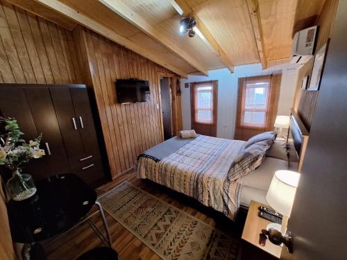 a small bedroom with a bed and a bathroom at Hostal Senderos del Sur in Freire