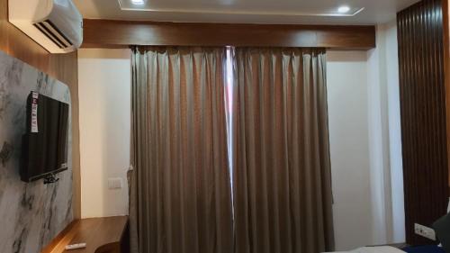 a bedroom with a shower curtain and a television at Hotel Vayu Banquet & Restaurant in Sasarām