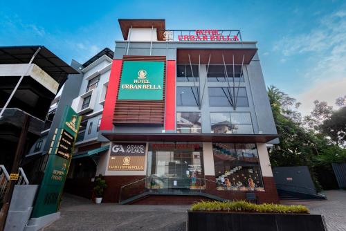 a building with a red sign on top of it at Hotel Urban Bella in Kozhikode
