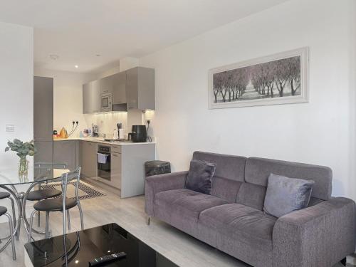 a living room with a couch and a kitchen at Blue Sapphire in Milton Keynes