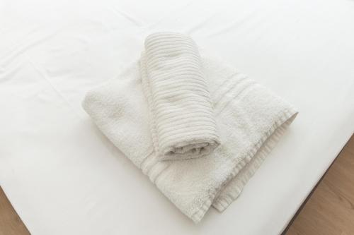 a white towel sitting on top of a bed at Orchidea House free Wifi, AC in Genova