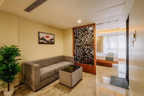 a living room with a couch and a bed at Hotel Urban Bella in Kozhikode