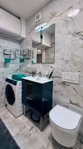 a bathroom with a sink and a washing machine at Mulino Apartments in Borek