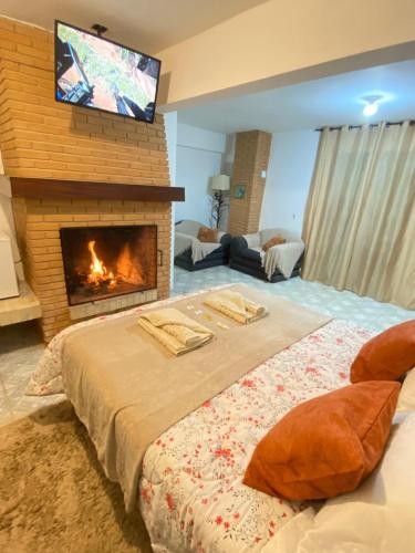 a bedroom with a bed with a fireplace and a tv at Villaggio Farnese in Campos do Jordão