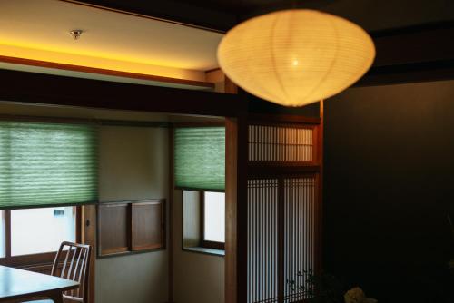 a room with a table and a lamp and windows at willow. in Toyooka