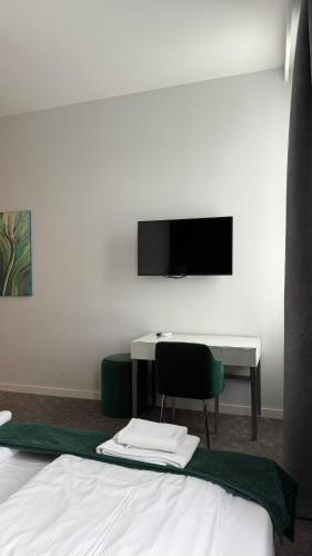 a bedroom with a bed and a desk and a television at Stara Biblioteka in Wrocław