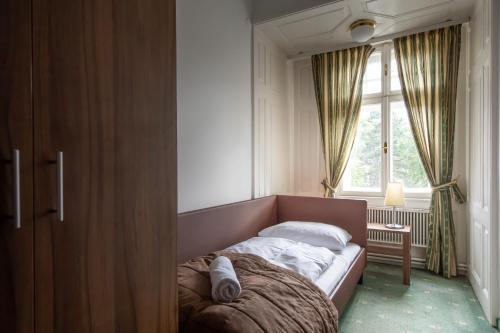 a bed in a bedroom with a window at Hotel Bergwirt Schönbrunn in Vienna
