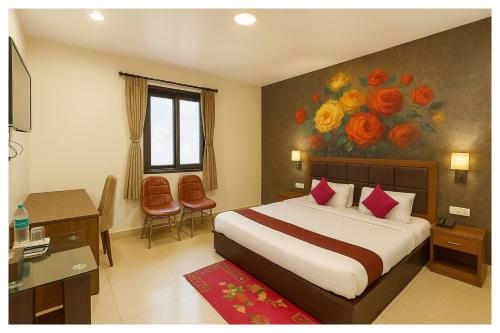 a hotel room with a bed and a painting of flowers at Hotel SS - Piper Near Sea Beach And Jagannath Temple in Puri