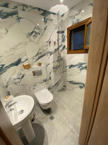 a bathroom with a white sink and a toilet at Villa Alexandra studios in Limenas