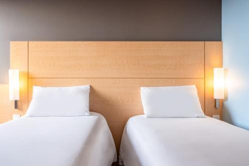 two beds sitting next to each other in a room at ibis Asuncion in Asuncion