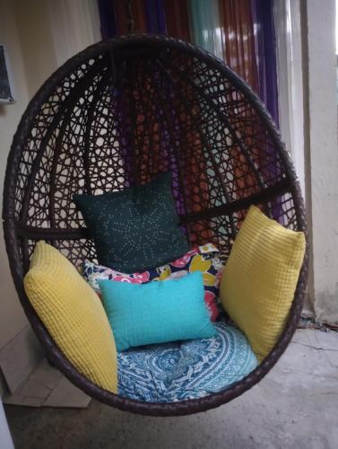 a wicker chair with pillows in a room at Casa Coco Cabana 
