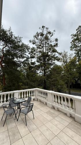 a patio with a table and chairs on a white fence at Stara Biblioteka in Wrocław