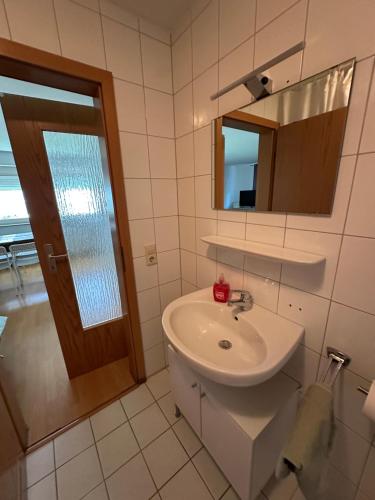 a white bathroom with a sink and a mirror at Apartment FIVE - EP Ticket Garantie in Rust