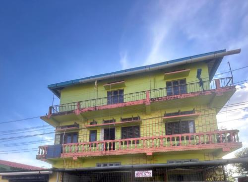 a yellow building with a balcony on top of it at Dream Nest Homestay in Tinsukia