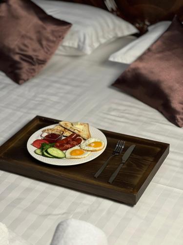 a plate of breakfast food on a tray on a bed at Sky luxe-hotel Astana in Astana
