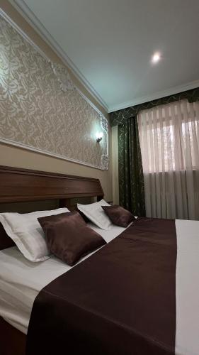 two beds in a hotel room with a window at Sky luxe-hotel Astana in Astana