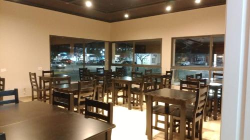 a dining room with tables and chairs and windows at Hotel Punto Sur Avenida in Malargüe