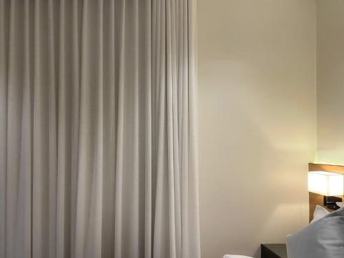 a curtain in a hotel room next to a bed at شقق خاصة بالقرب من برج الفيصلية in Riyadh