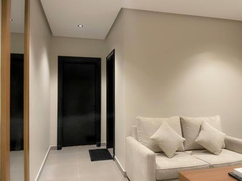a living room with a white couch and a black door at شقق خاصة بالقرب من برج الفيصلية in Riyadh