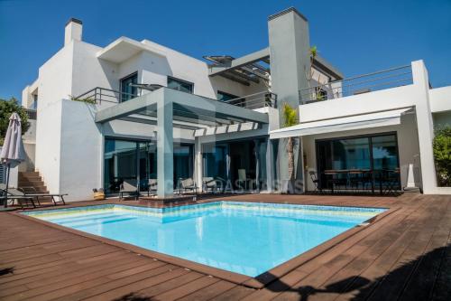 a villa with a swimming pool and a deck at Aqua Villa by AcasaDasCasas in Ericeira