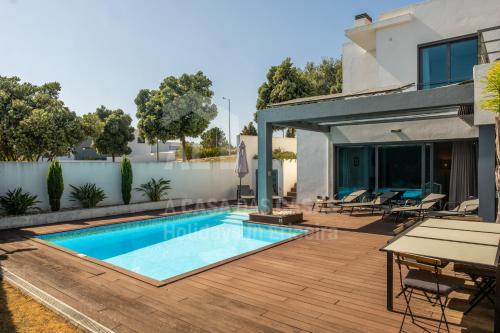 a swimming pool on a deck next to a house at Aqua Villa by AcasaDasCasas in Ericeira