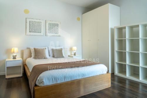 a bedroom with a bed and a book shelf at Aqua Villa by AcasaDasCasas in Ericeira