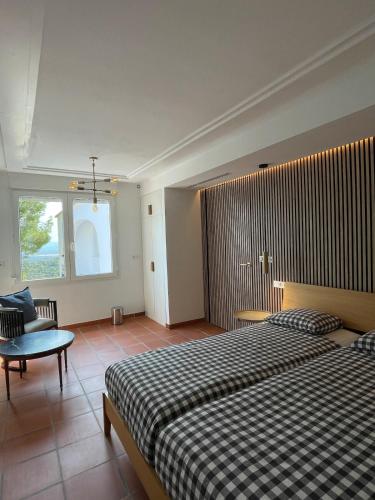 a bedroom with a bed and a chair and a window at A Design Casa in Own Private Hills for Adult Only in Alginet