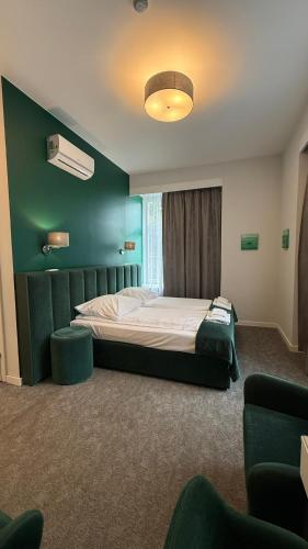 a bedroom with a bed with a green wall at Stara Biblioteka in Wrocław