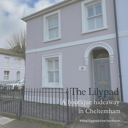 a white house with a fence in front of it at The Lily Pad - Boutique Townhouse, a short walk to Town Center and Racecourse in Cheltenham