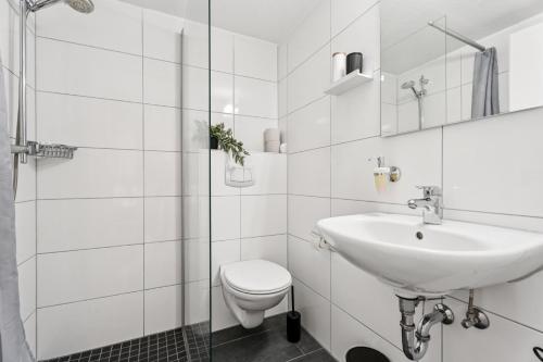 a white bathroom with a toilet and a sink at 3 Schlafplätze - Zentral, Ruhig, Terrasse, Küche in Bocholt