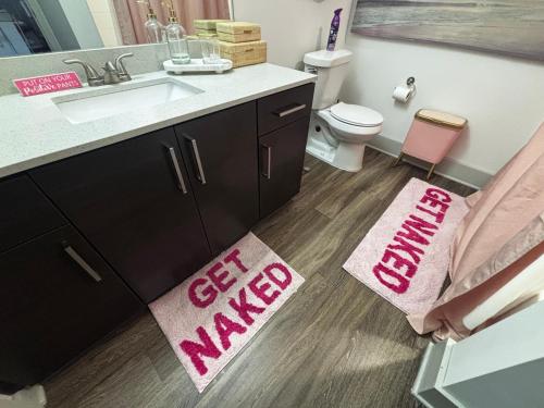 Un baño con lavabo, inodoro y alfombra. en Cozy Luxury Home, en Atlanta