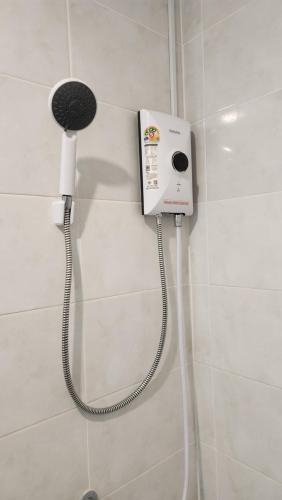 a phone on the wall of a shower in a bathroom at Rich Bar & House in Pattaya