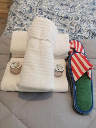 a bed with two towels and two clocks on it at Newly amazing refurbished two bedroom apartment in Harrow on the Hill