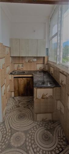 a kitchen with a tiled floor and a window at Prem Home Stay in Rishīkesh