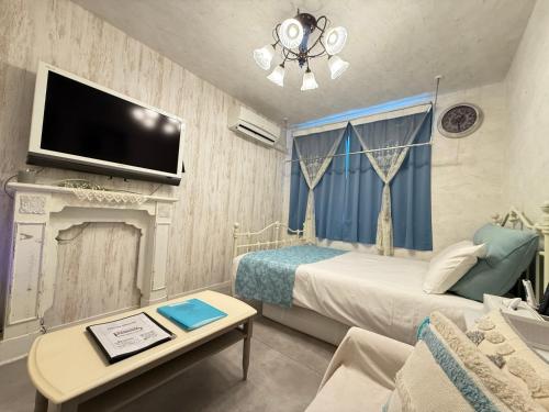 a bedroom with a bed and a tv on a wall at Eternity APARTMENT HOTEL SHINAGAWA in Tokyo